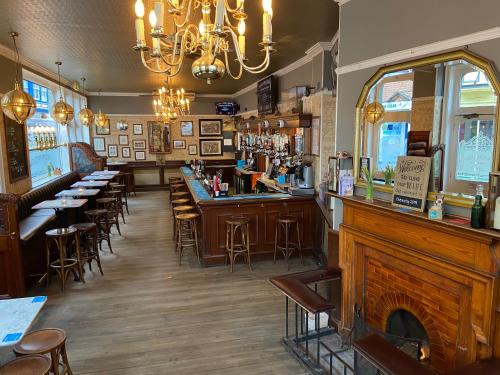 克羅默的住宿－The Wellington Pub Cromer，餐厅设有酒吧,配有桌椅
