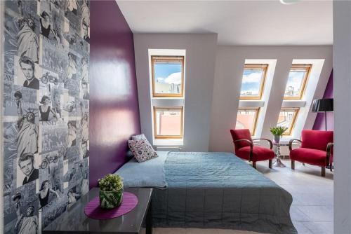 1 dormitorio con cama y pared púrpura en Apartament Broadway en Poznan