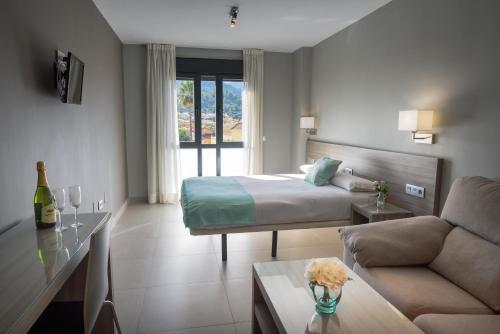a hotel room with a bed and a couch at Apartamentos Santa Clara in Alhaurín de la Torre