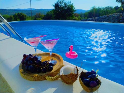 bandeja de fruta y bebidas en una mesa junto a la piscina en Holiday Home Sego with Private Pool, en Veliki Broćanac