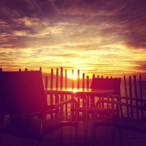 a table and chairs in front of a sunset at La Rosa dei Venti Resort in Piombino