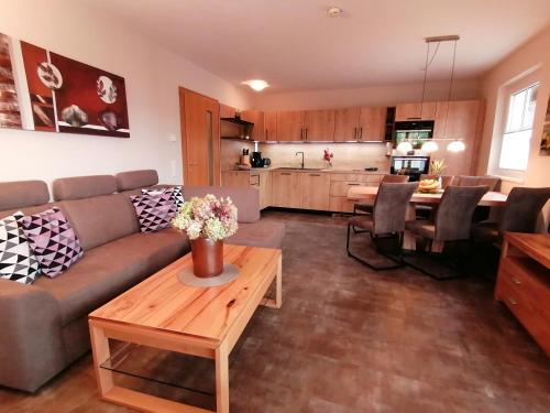 ein Wohnzimmer mit einem Sofa und einem Tisch in der Unterkunft Komfort Appartements serviced by Auhof in Kaprun