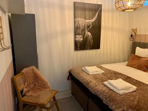 a bedroom with a bed and a picture of a bull at Amsterdam Beach Apartment 80 in Zandvoort