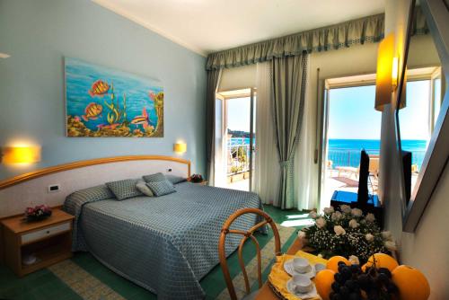 a bedroom with a bed and a view of the ocean at Grand Hotel Il Ninfeo in Gaeta