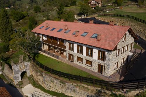 Apartamentos Los Picos de Europa في Colio: اطلالة جوية على منزل بسقف احمر