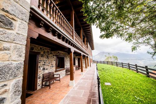 a stone building with a bench next to a fence at Apartamentos Los Picos de Europa in Colio
