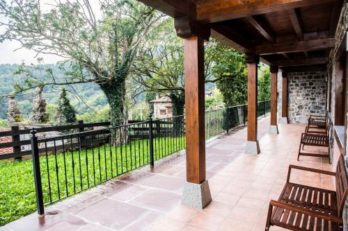 an outdoor porch with benches and a fence at Apartamentos Los Picos de Europa in Colio