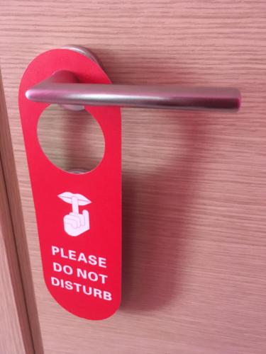 a red doorhandle with a do not disturb sign on it at B&B Luce Viola in Dorgali