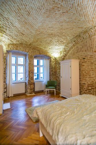 a bedroom with a large bed in a brick wall at Cluj Apartments in Cluj-Napoca