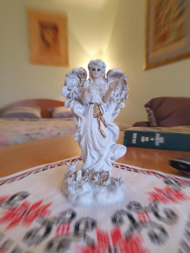 een wit engelenbeeld op een tafel bij House Hotel Apartments 2 in Rivne