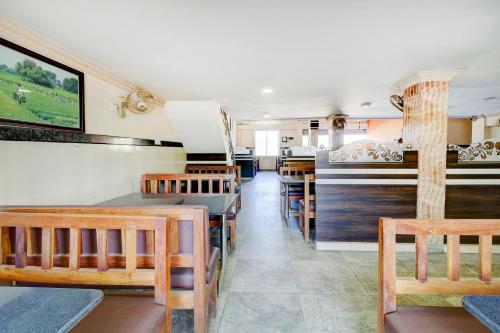 una sala da pranzo con tavoli e sedie in legno di Gaurika Residency Boarding & Lodging - Padubidri a Padubidri