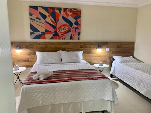 a bedroom with a bed with a teddy bear on it at Pousada Pedras Brancas in Niterói