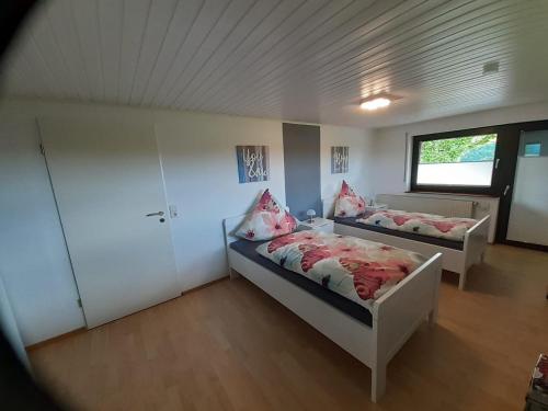 a bedroom with two beds and a window at Ferienwohnung Vergissmeinnicht in Osburg