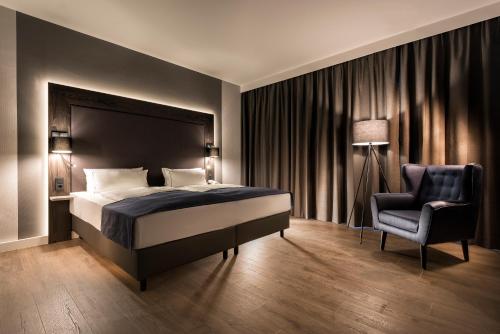 um quarto com uma cama e uma cadeira em Holiday Inn Berlin City-West, an IHG Hotel em Berlim