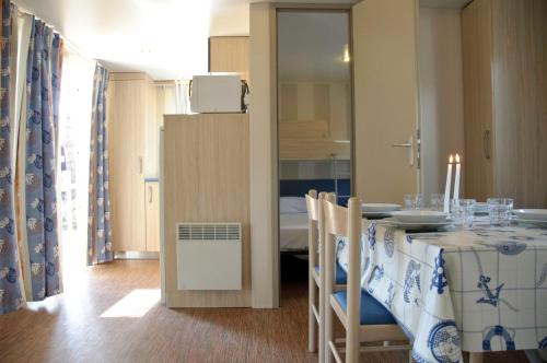 a dining room with a table and a room with a bedroom at Club del Sole Vigna sul Mar Family Collection in Lido di Pomposa