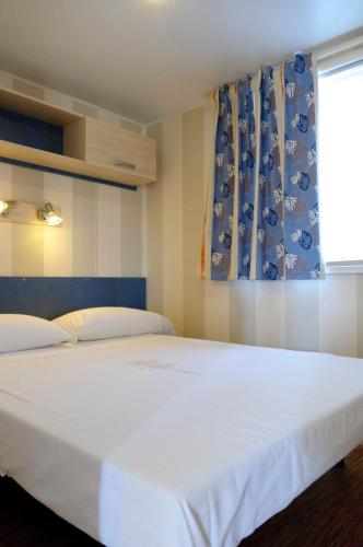 a bedroom with two beds and a window at Club del Sole Vigna sul Mar Family Collection in Lido di Pomposa
