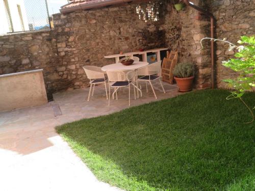 a patio with a table and chairs in a yard at Appartamenti Il Castellaccio in San Siro