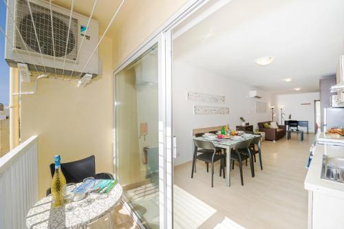 een keuken en een woonkamer met een tafel en stoelen bij Summer Breeze Comfort Sunny Apartments close to the sandy beaches - by Getawaysmalta in Mellieħa