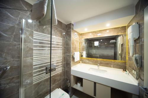 マニサにあるSpilos Hotelのバスルーム(洗面台、トイレ、鏡付)