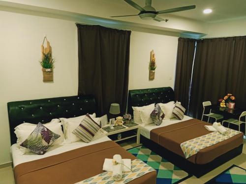 a bedroom with two beds and a table and chairs at Studio I-Soho D'Gunduls Homestay by DGH I-CITY in Shah Alam