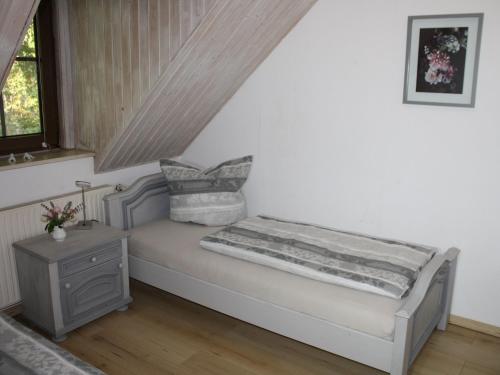 a small bed in a room with a window at Zu den grauen Ziegenböcken in Serba
