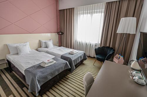 a hotel room with two beds and a table at NoBo Hotel - business in Łódź