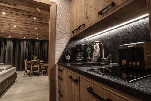 a kitchen with a sink and a room with a bed at Apartment Alpinflair 1 in Kaprun