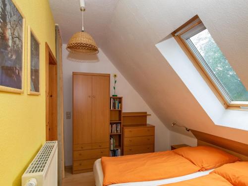 Schlafzimmer im Dachgeschoss mit einem Bett und einem Fenster in der Unterkunft Ferienwohnung Letsch in Burg
