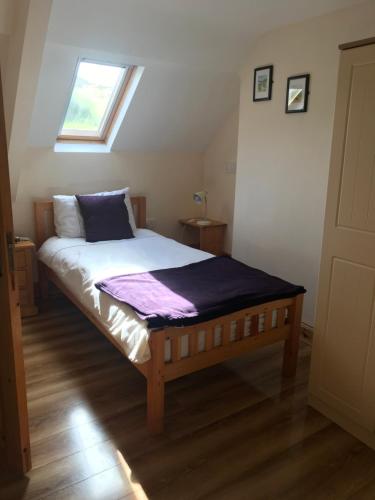 Bett in einem Zimmer mit Fenster in der Unterkunft Cappa House B&B in Eyeries