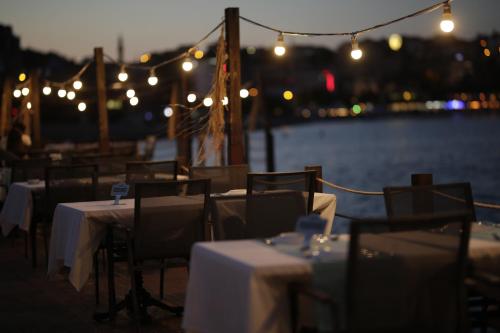 a group of tables and chairs with lights on a boat at Northdoor Hotel in Amasra