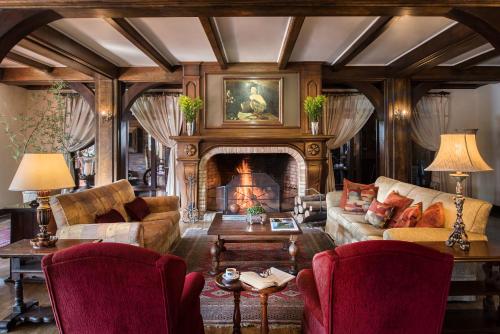 a living room with a fireplace and a couch and chairs at Serrazul Hotel Distributed By Intercity in Gramado