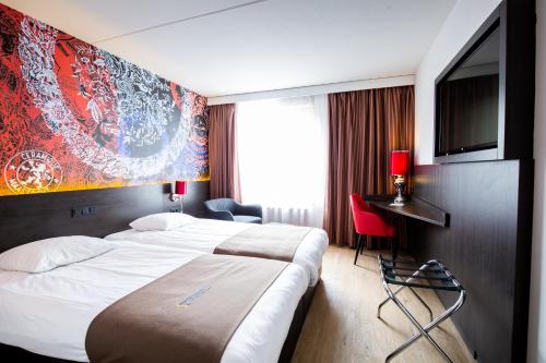 a hotel room with a bed and a flat screen tv at Bastion Hotel Maastricht Centrum in Maastricht
