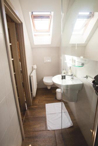 a bathroom with a sink and a toilet and skylight at Penzion Trattoria in Prešov