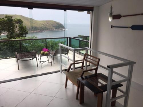 a room with a balcony with a table and chairs at Paraíso de Toque Toque Grande in São Sebastião