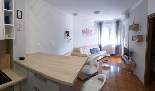 a kitchen and living room with a table and chairs at Apartman Jelacic Vinkovci in Vinkovci