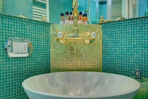La salle de bains est pourvue d'un lavabo et d'un mur carrelé vert. dans l'établissement GranDELUX-Canal, à Venise