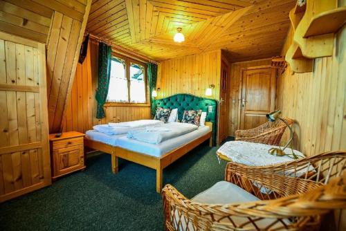 a bedroom with two beds and wicker chairs at Osada na Brzyzku in Poronin