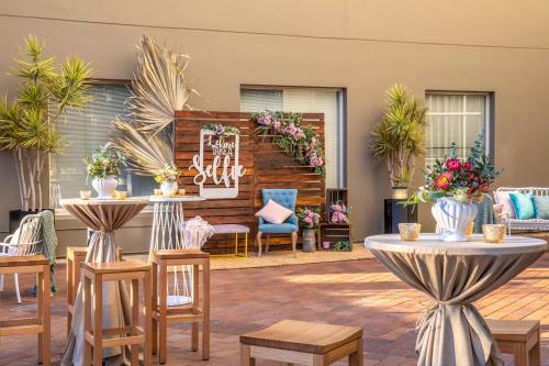 a patio with tables and chairs and flowers at Holiday Inn Sydney Potts Point in Sydney