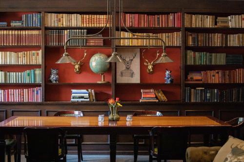biblioteca con tavolo, sedie e libri di Restaurant & Hotel Hoog Holten a Holten