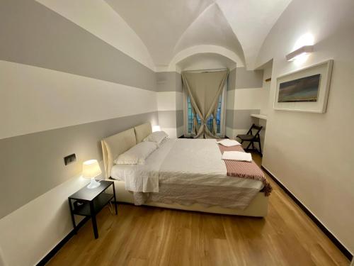 ein kleines Schlafzimmer mit einem Bett und einem Fenster in der Unterkunft New Apartament in historical Genoa center in Genua