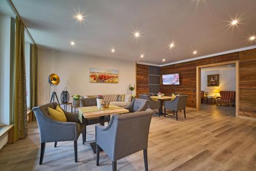 a living room with tables and chairs and a dining room at Gästehaus Huber - Hotel Garni in Bad Füssing