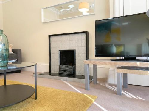 a living room with a tv and a fireplace at Tay View Apartment in Dundee
