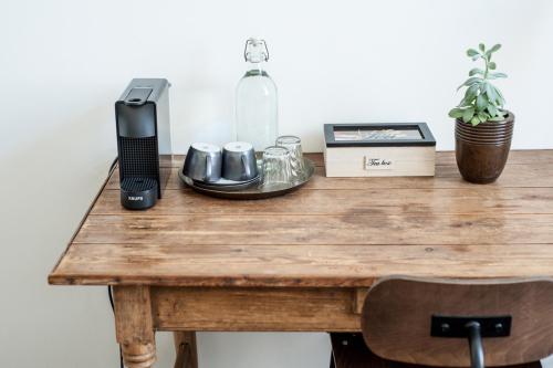 a wooden table with a phone and a bottle on it at B'Guest Sleep & Retreat in Bruges