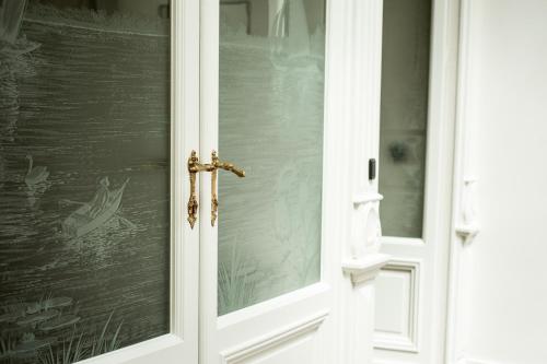 a white door with a gold door handle at B'Guest Sleep & Retreat in Bruges