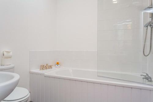 bagno bianco con vasca e servizi igienici di Cherry Property - Apple Suite a Blackpool