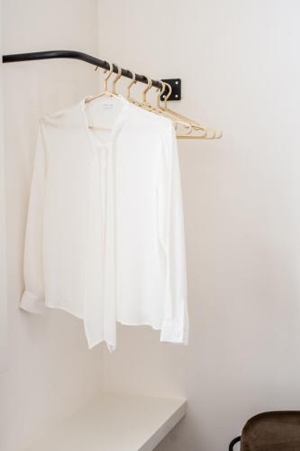 a rack with white shirts hanging on a wall at B'Guest Sleep & Retreat in Bruges