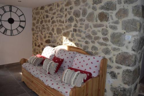 um sofá num quarto com uma parede de pedra em Gîte Le Pilat em Vernoux-en-Vivarais