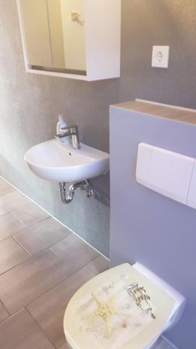 a bathroom with a sink and a toilet at Flensburg City - 24h in Flensburg