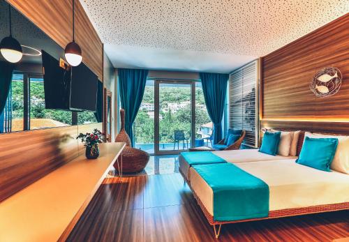 a bedroom with a large bed with blue pillows at Carine Hotel Kumbor Superior in Herceg-Novi
