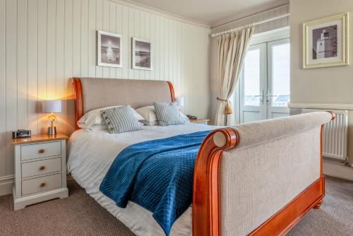 Botany Bay Hotel في برودستيرز: غرفة نوم مع سرير وبطانية زرقاء